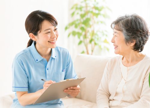 ソファで高齢女性の話を聞くスタッフ