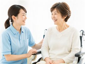 車いすの女性と話す訪問リハビリのスタッフ
